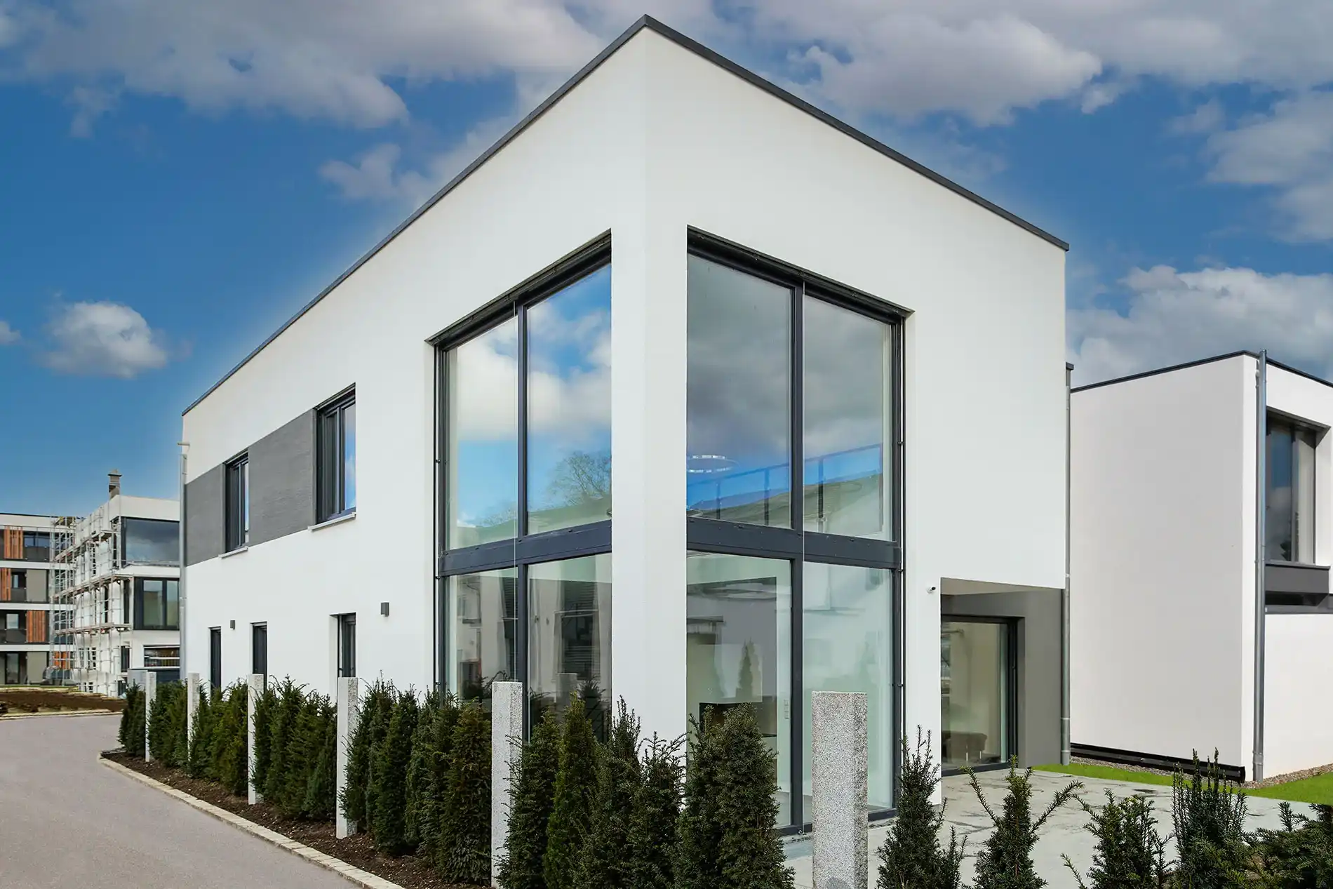 Modernes weißes Einfamilienhaus mit Flachdach und großen Glasfronten